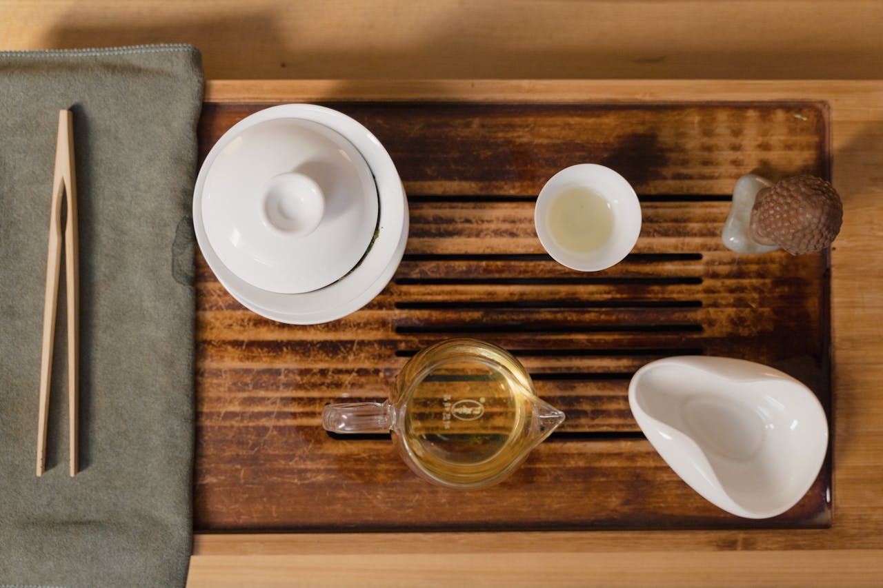 Elegant Chinese tea set with cha hai and gaiwan on a wooden tray, ideal for tea ceremony enthusiasts.